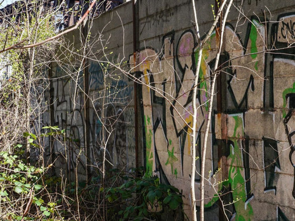 Sicherungsmauer entlang der Bahnlinie und Betonzaunpfosten zur Befestigung des Grenzzauns auf dem Domfriedhof der St. Hedwigsgemeinde an der Liesen-/Ecke Gartenstraße; Aufnahme 2015