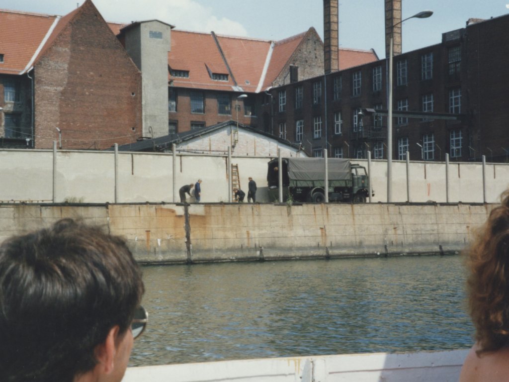 Berlin tourists can watch from the Spree as border soldiers remove signal elements from the Wall
