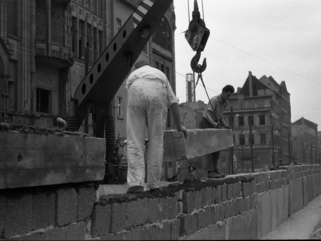 DDR-Bauarbeiter erhöhen unter Bewachung von Grenzposten die Mauer; Aufnahmedatum unbekannt