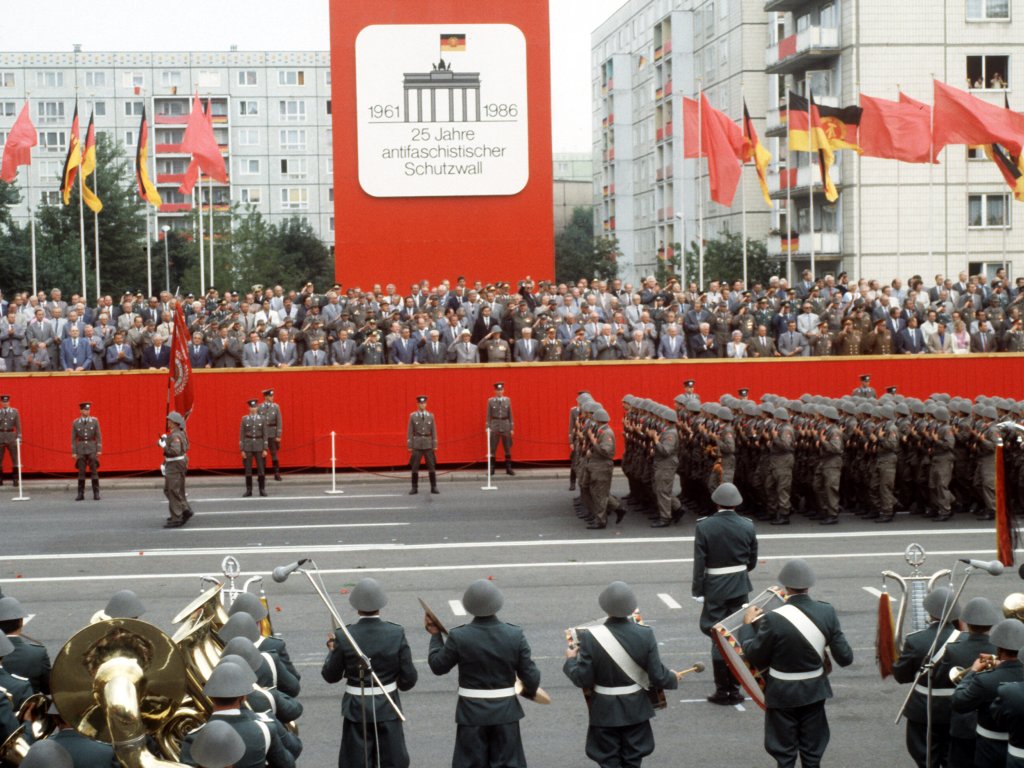1986: Am 25. Jahrestag des Mauerbaus treten Formationen der Nationalen Volksarmee und der Kampfgruppen der DDR zu einem Appell vor der Ehrentribüne der DDR-Partei- und Staatsführung in der Karl-Marx-Allee in Ost-Berlin an.